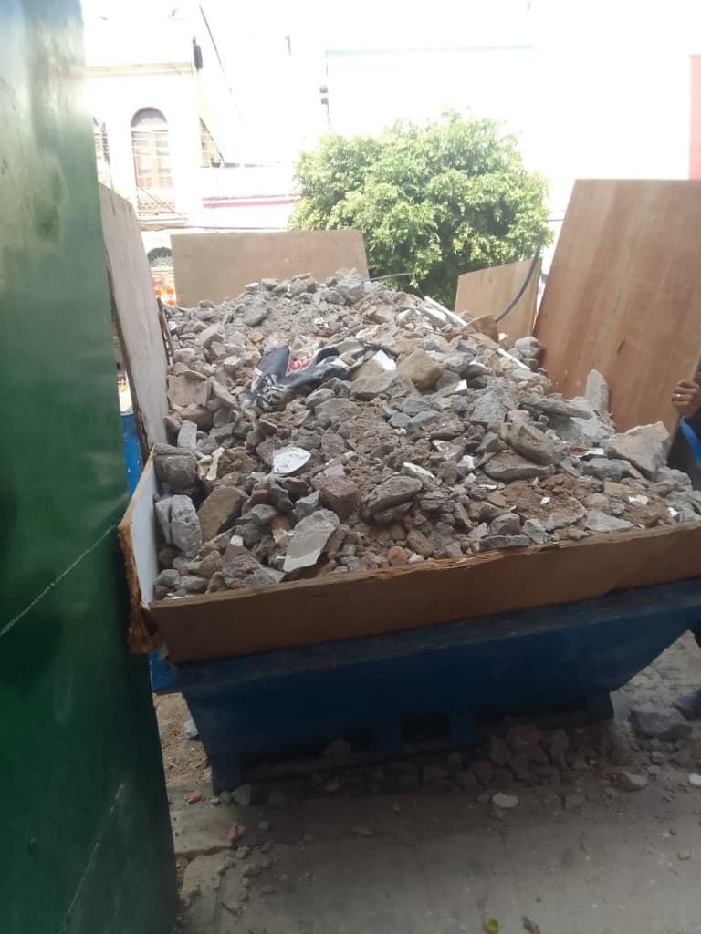 Exemplo proibido: caixa coletora com paredão de madeira e entulho acima da borda